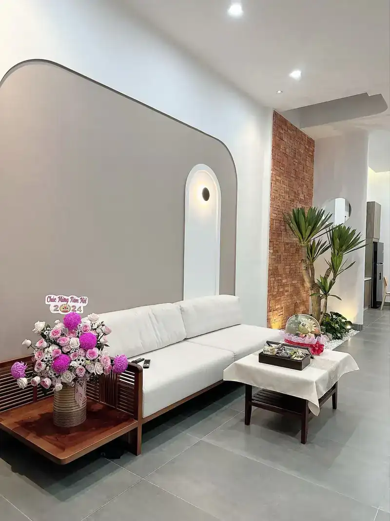 Phòng khách B-House Kon Tum — sofa trắng, vách vòm, tường gạch thẻ, 2 phòng ngủ nhà cấp 4