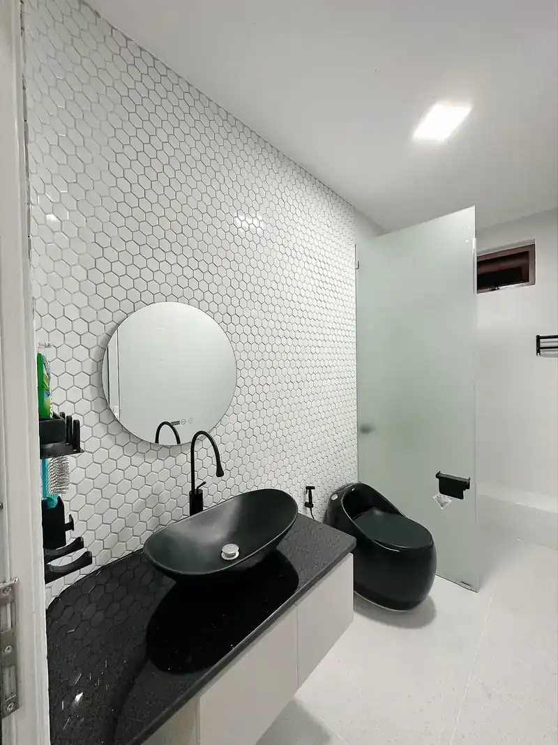 WC nhà cấp 4 B-House Kon Tum — gạch lục giác, lavabo đen, bồn cầu đen