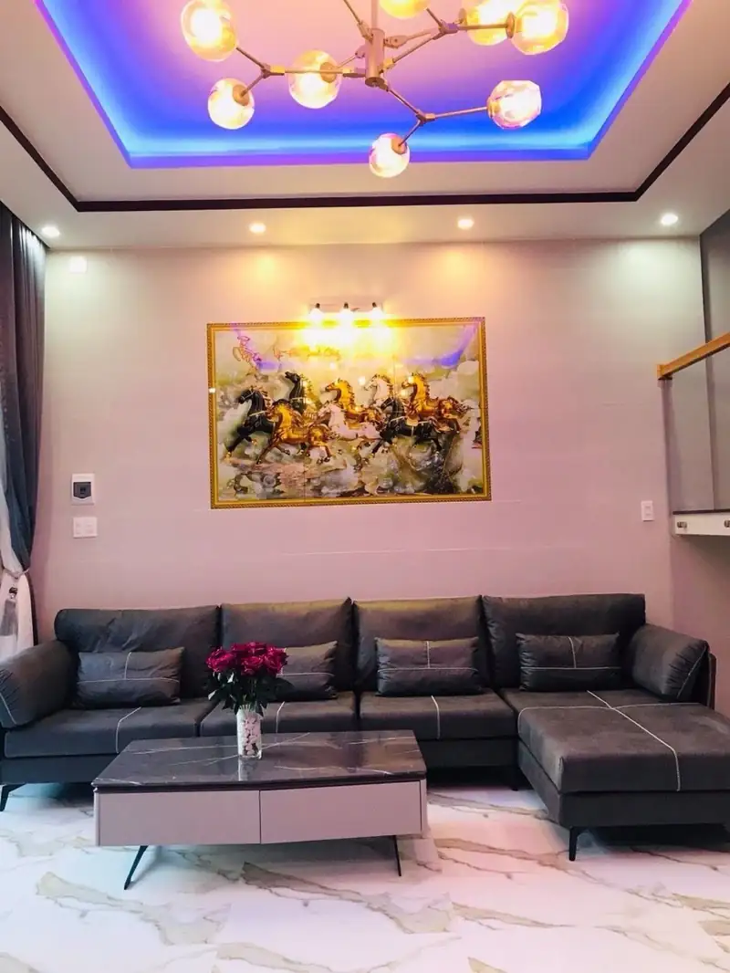 Phòng khách CP-House trần hắt LED xanh, đèn chùm, sofa xám — thiết kế nhà đẹp Kon Tum