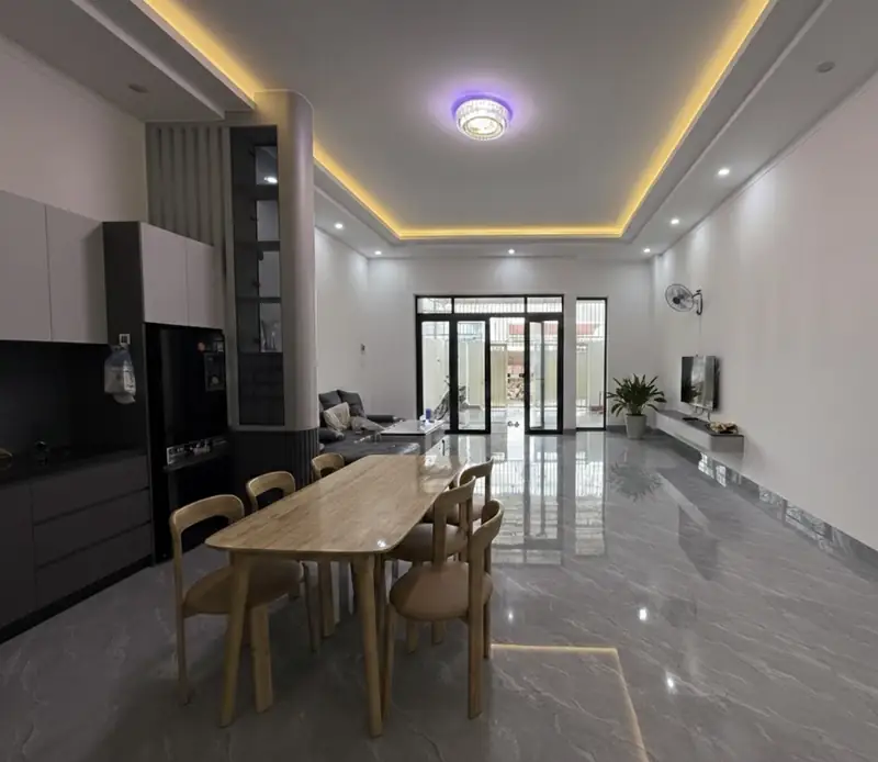 Phòng khách nhà phố 6x25 nhìn ra sân — sofa xám, cửa kính, thiết kế nhà đẹp Kon Tum