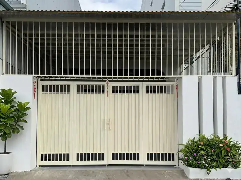 Cổng sắt nhà phố ĐV-House 6x25 Kon Tum — bốn cánh sơn kem, mái tôn che sân để xe