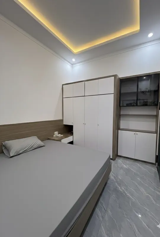 Phòng ngủ nhà phố ĐV-House Kon Tum — tủ trắng khung gỗ, trần hắt sáng