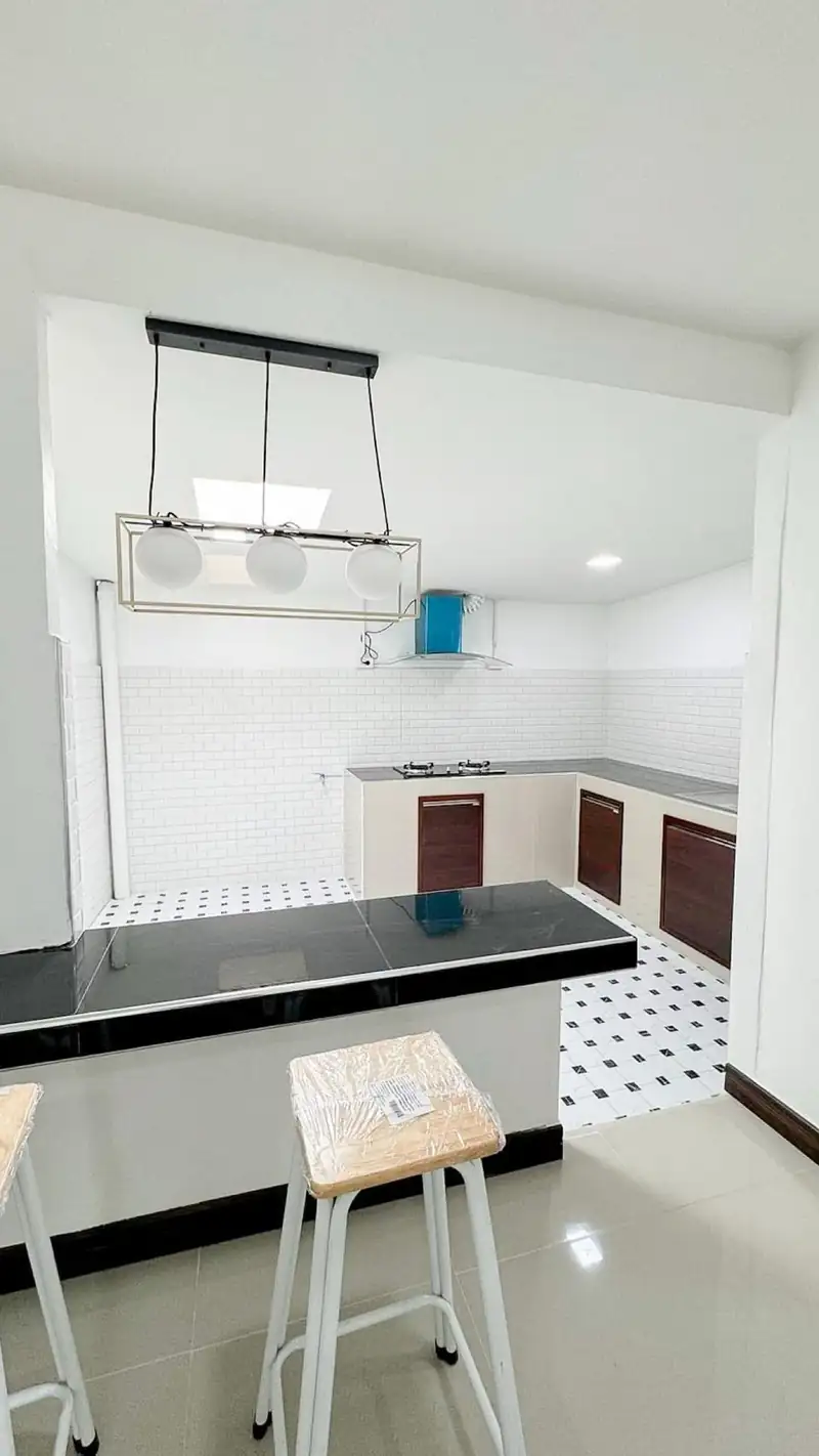 Đảo bếp đá đen nhà cấp 4 MN-House Kon Tum — ghế bar, bếp chữ L sau cải tạo