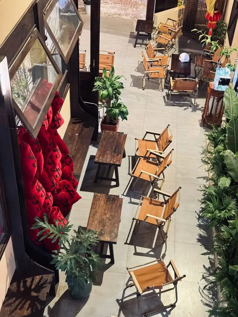 Nhìn từ trên sân trong Mộc Cafe — cây, ghế, tấm bê tông đục lỗ, quán 8x16 Kon Tum