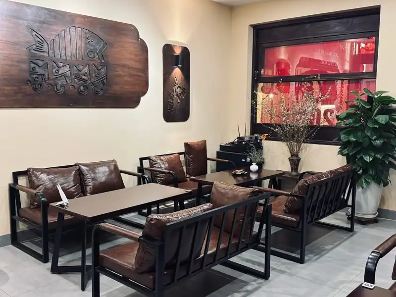Ghế da và tượng gỗ cá Mộc Cafe Kon Tum — nội thất quán cafe đã mở