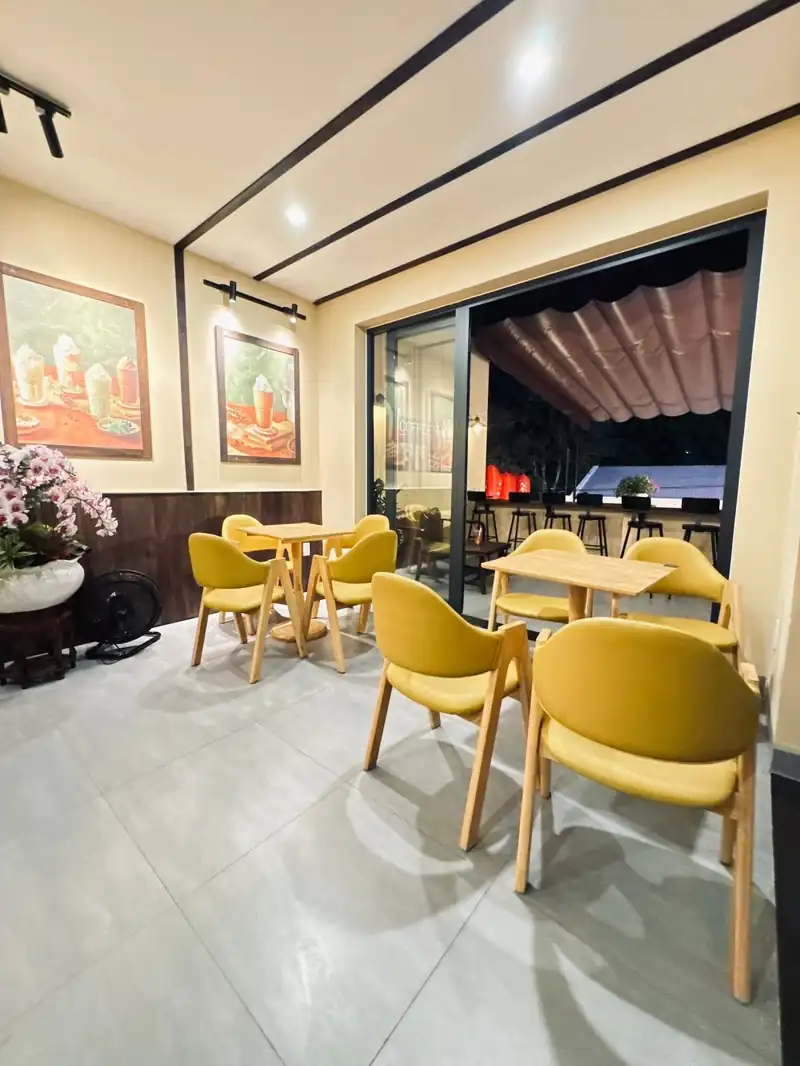Tầng 2 Mộc Cafe — ghế vàng, cửa kính trượt ra sân thượng, không gian ở
