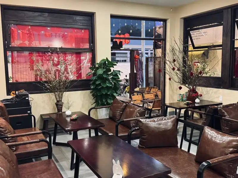 Bên trong Mộc Cafe nhìn ra đường — cửa sổ gỗ, sofa da, quán cafe 2 tầng Kon Tum