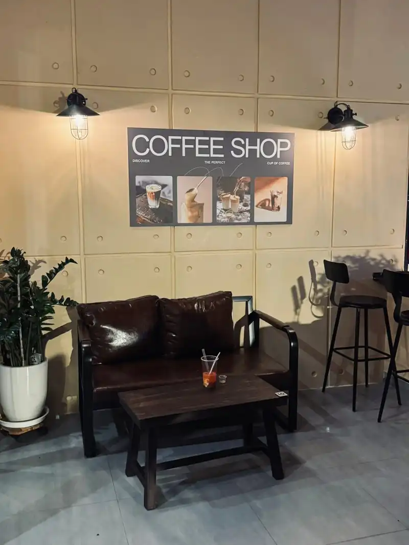 Sofa nâu và tường poster Mộc Cafe Kon Tum — ghế bar, thiết kế quán cafe