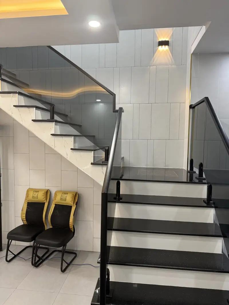 Cầu thang giữa nhà ống 4m Kon Tum — lan can kính, gạch xám, Salon Công